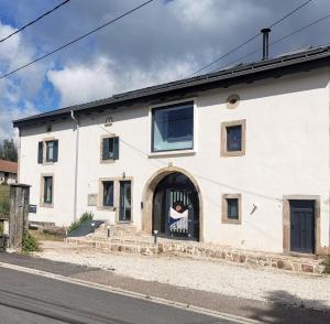 a white building with a door with a sign on it at Mozane in Chantraine