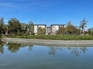 a reflection of buildings in a body of water at Apartment Park in Novi Sad