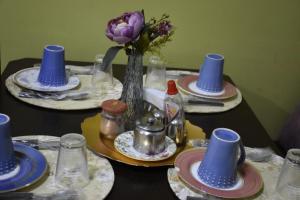 a table with blue hats and plates and a vase of flowers at CALDAS NOVAS RESIDENCE - Inclui um ingresso por pessoa em Parque Aquático por diaria e temos , HOT PARK, LAGOA PARQUE E OUTROS PARQUES a preço promocional in Caldas Novas