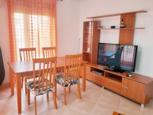 a dining room with a table and a television at EDIFICIO ALGAIDA - NEW VISTA MONTAÑA - PLAYA DE LA CONCHA in Oropesa del Mar