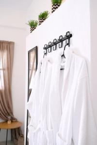 a white shirt hanging on a wall next to a mirror at Panorama View Kanala in Kithnos +55 photos