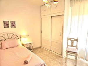 a bedroom with a bed and a chair and a window at ALBAREÍLLA by #cherrygredos in El Arenal