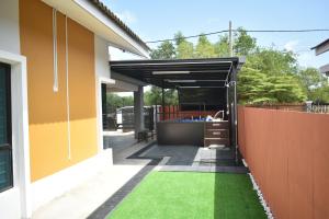 a backyard with a fence and green grass at Dj Impiana Homestay - Private Kids Pool in Kampung Raja