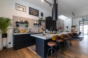 a kitchen with black cabinets and a bar with stools at Zen House in Zadar