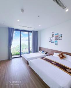 a bedroom with two beds and a large window at Ibiza Hải Tiến in Thanh Hóa