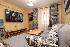 a living room with a couch and a flat screen tv at Limpopo House 2 bedroom in Naivasha