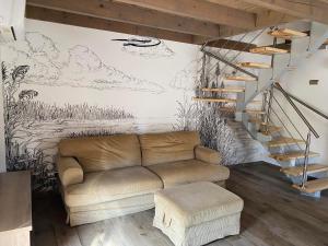a living room with a couch and a staircase at Ábrahámhegyi Nyaralóház in Ábrahámhegy