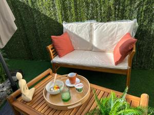 a patio with a couch and a table with a tray of food at La Belle Echappée Pyrénéenne in Lourdes