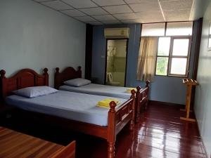 two twin beds in a room with a shower at Baan Lotus Guest House in Phra Nakhon Si Ayutthaya