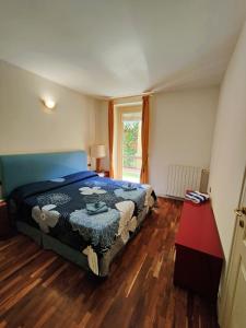 a bedroom with a bed and a window and wooden floors at Scarlet Flower - Lago Maggiore in Meina