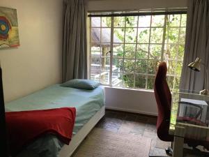 a bedroom with a bed and a large window at Fully Furnished 3 Bedroom House In in Pentagon Park Bloemfontein in Bloemfontein