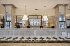 a lobby with three pendant lights and a checkered floor at Windsor Marapendi Hotel in Rio de Janeiro