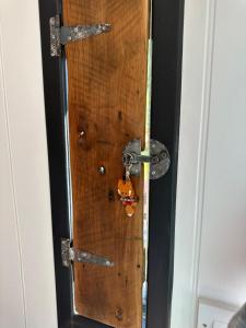 a wooden door with a knocker on it at A Snuggles hut in Faversham +7 photos