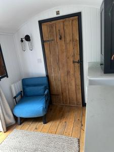 a blue chair sitting in front of a door at A Snuggles hut in Faversham
