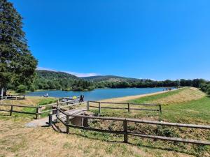 a group of wooden fences next to a lake at Au Grand Mûrier in Roquefère +1 photo