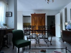 a room with chairs and a table and a television at Apparemment Blagnac proche TRAM in Blagnac