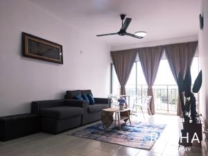 a living room with a couch and a table at Rycha Homestay A famosa near Waterpark in Kampong Pulau Sebang