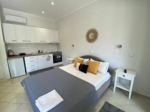 a small bedroom with a bed and a kitchen at Villa Loukia in Corfu