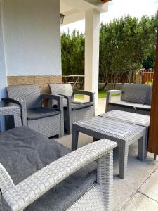 grupa krzeseł i stołów na patio w obiekcie Domek MESSA ACHKASZUBY w mieście Puck +3 zdjęcia