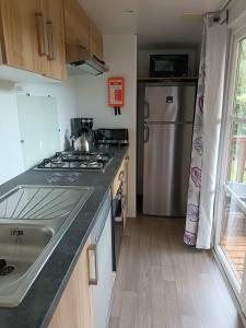 Una cocina con estufa, fregadero y refrigerador. en Standing PREMI-HOME moderne et spacieux 25min Puy DuFou 700RC, en La Boissière-de-Montaigu