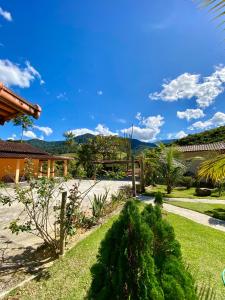 a view of a garden with mountains in the background at Pousada Pedra Grande - SANA in Macaé