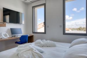 a bedroom with a bed with a desk and a computer at Maison des Marais 5 Etoiles La Chaume Piscine in Les Sables-dʼOlonne +15 photos