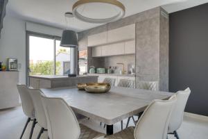 a kitchen and dining room with a table and chairs at Maison des Marais 5 Etoiles La Chaume Piscine in Les Sables-dʼOlonne