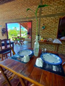 a wooden table with two plates and a bottle on it at Icarai Kite House in Icaraí +128 photos