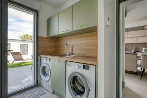 a laundry room with a washer and dryer in a house at Maison des Marais 5 Etoiles La Chaume Piscine in Les Sables-dʼOlonne
