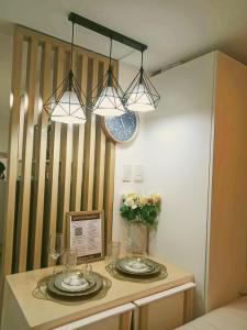 a table with two plates and glasses and a clock at Sam's Chic Space - An Aesthetic Getaway in Angeles