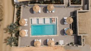 an overhead view of a swimming pool with chairs and umbrellas at Naxos Cave Suites in Stelida