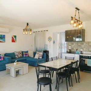 a living room with a table and a blue couch at Mountain view North Coast Ras elhekma, Tart's Home, Families only in Ras Elhekma