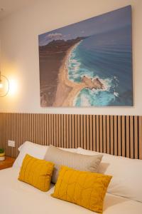a bedroom with a bed with yellow pillows and a beach at Villa Mahor in La Oliva +36 photos