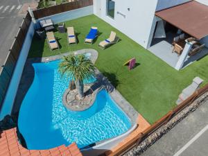 an overhead view of a swimming pool with chairs and a palm tree at Villa Mahor in La Oliva