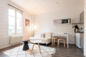 a living room with a couch and a table at Joli studio plein centre proche plage avec Wi-fi in Le Touquet-Paris-Plage