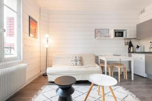a living room with a couch and a table at Joli studio plein centre proche plage avec Wi-fi in Le Touquet-Paris-Plage
