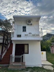 uma casa branca com varanda e escadas em The Olive em Čanj