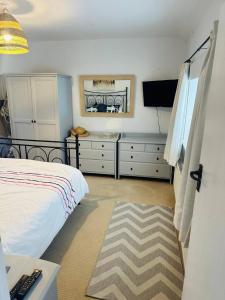 ein Schlafzimmer mit einem Bett und einem Flachbildfernseher in der Unterkunft Detached cottage near to Abersoch in Abersoch