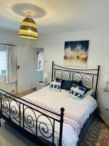 ein Schlafzimmer mit einem großen Bett mit blauen und weißen Kissen in der Unterkunft Detached cottage near to Abersoch in Abersoch