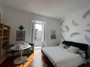 a bedroom with a bed and a table and a window at Casa Boccardi in Taranto