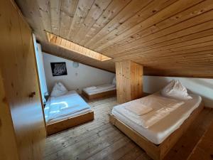 two beds in a room with a wooden ceiling at Haus Imbachhorn Summer Card included in Zell am See