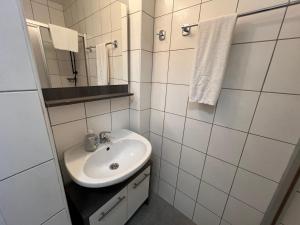 a white bathroom with a sink and a mirror at Haus Imbachhorn Summer Card included in Zell am See +70 photos