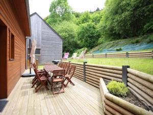 une terrasse en bois avec une table et des chaises dessus dans l'établissement Chalet moderne 92m² avec garage, bornes de recharge, Wi-Fi, proche du centre - FR-1-608-206, à Le Mont-Dore