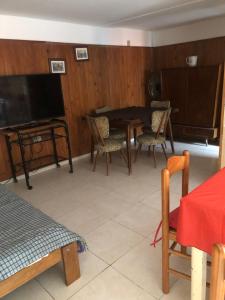 a living room with a table and chairs and a tv at Casa de Myri in Villa Carlos Paz