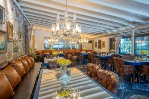a dining room with tables and chairs and a chandelier at simlarda aquapark otel in Ayvalık