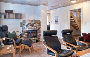 a living room with chairs and a stone fireplace at Hytte 1 in Øvre Ramse
