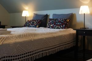a bedroom with a bed with pillows and two lamps at Helluland Guesthouse in Sauðárkrókur