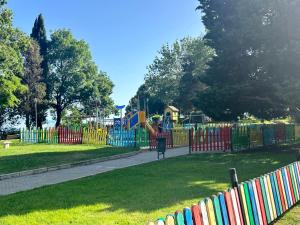 a playground in a park with a colorful fence at Seaside Apartment Nesebar in Nesebar