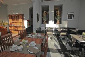 a dining room with tables and chairs and statues at Das Nikolai Hotel in Munich