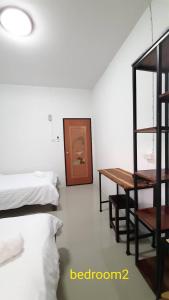 a bedroom with a bed and a desk and a table at Rutcha homestay Betong รัชชา โฮมสเตย์ เบตง in Betong